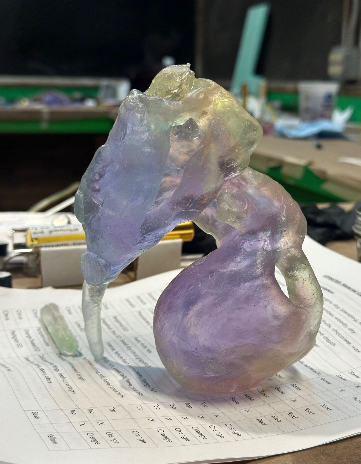 Iridescent lilac glass snail sculpture on a worksheet
