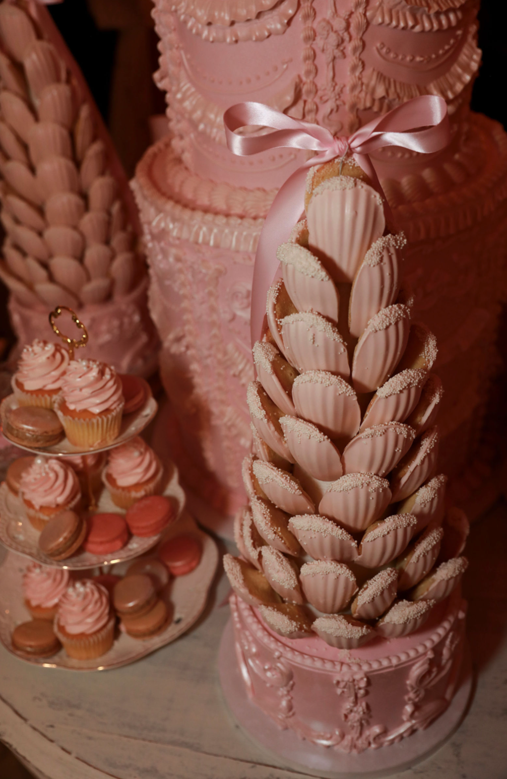 Pink cakes, cupcakes, and madeleines at a Love Shack Fancy event