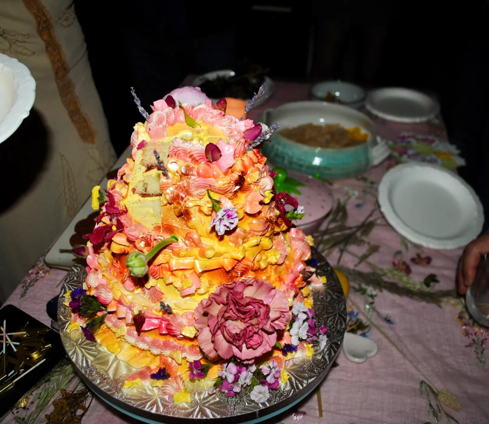 A colorful tiered cake decorated with flowers at a reading