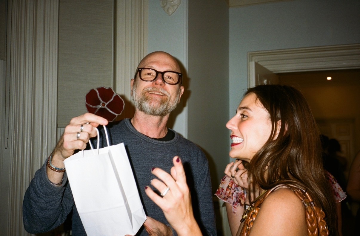 A smiling guest holding a gift bag at a reading