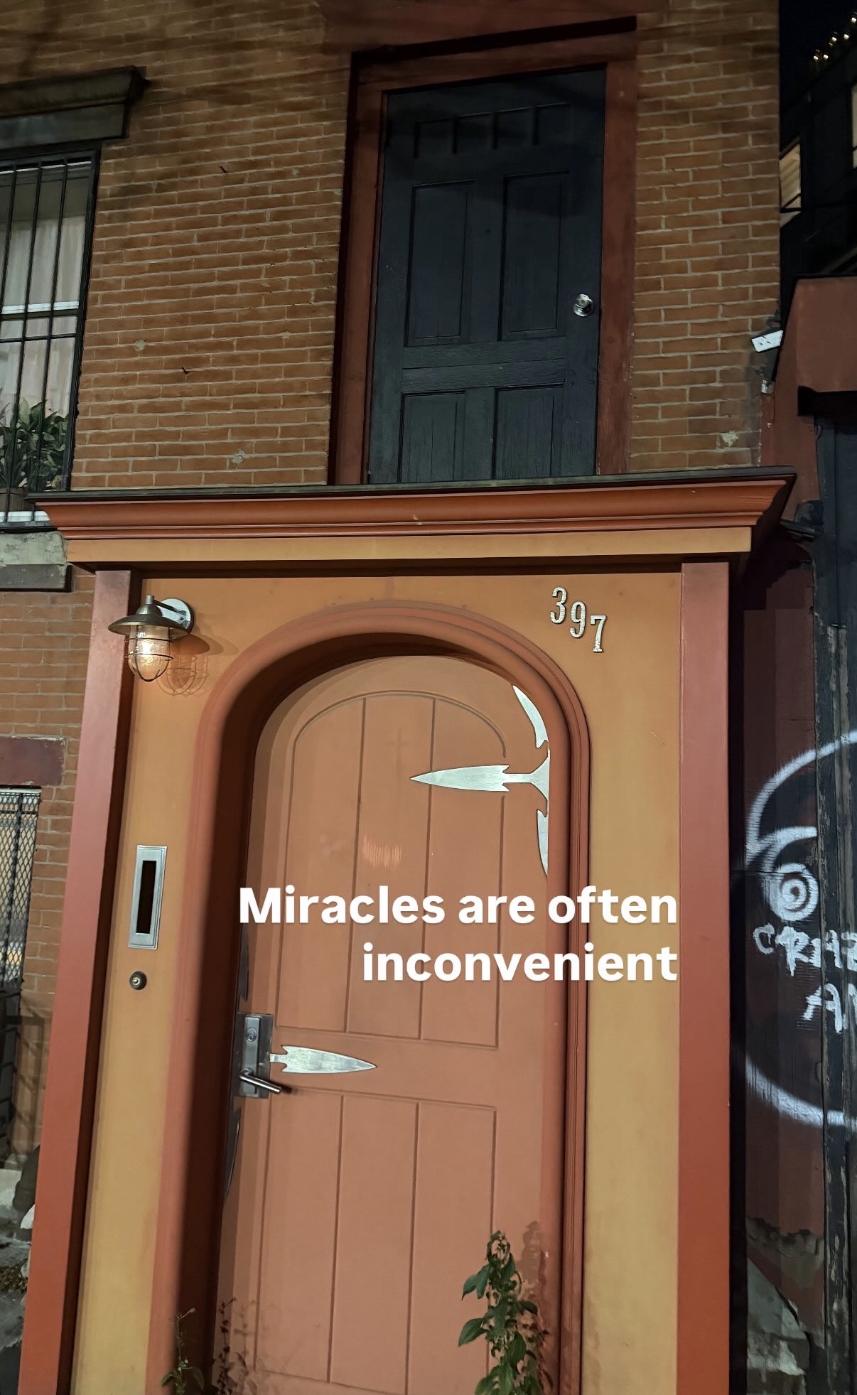 Pink door with graffiti, captioned: Miracles are often inconvenient
