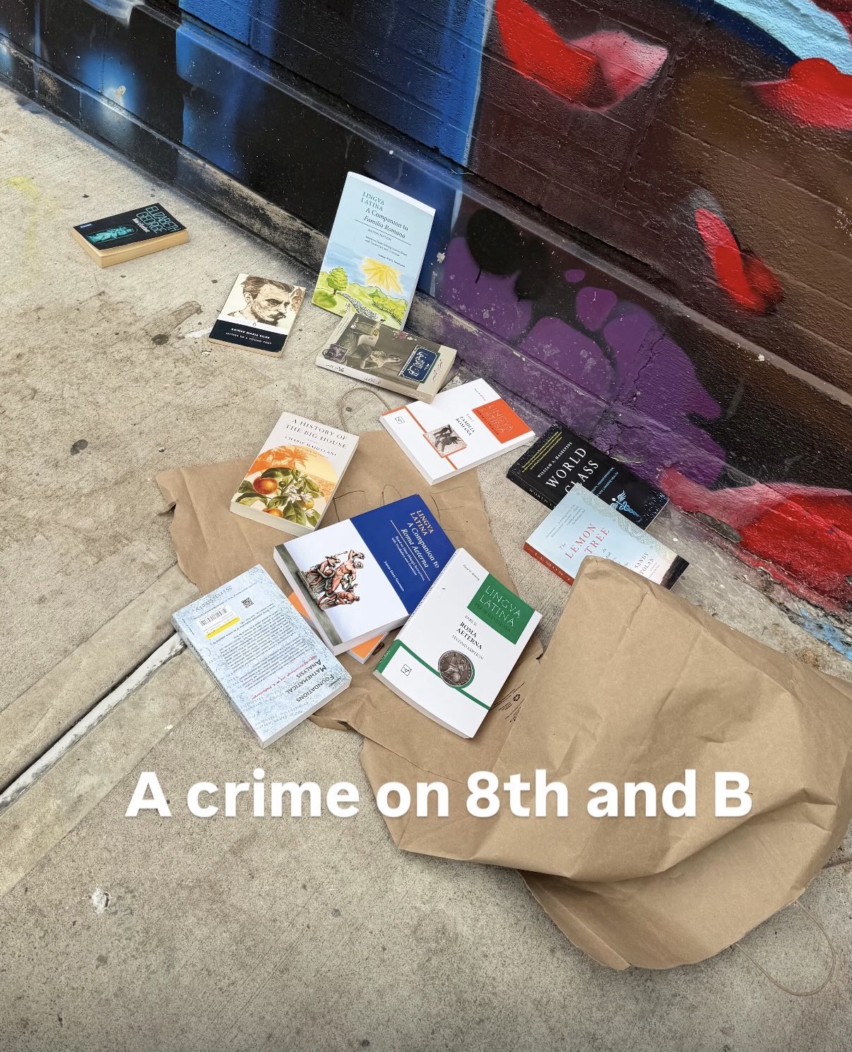 Books spilled on a sidewalk, captioned: A crime on 8th and B